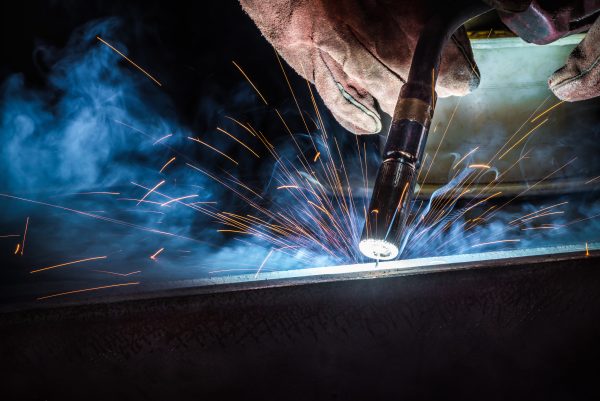 Industrial welder welding fabricated construction in factory, We